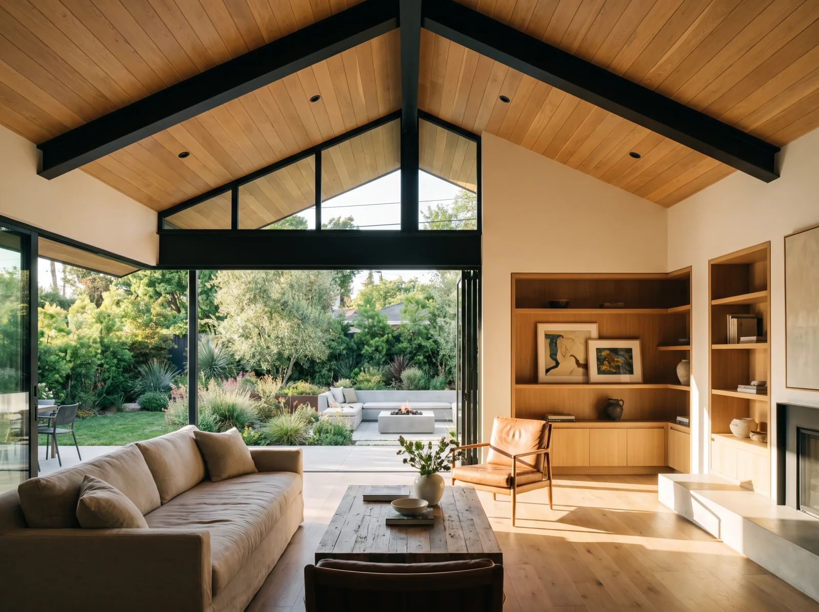 Finished modern home addition great room with vaulted wood ceiling, exposed steel beams, and sliding glass doors to backyard