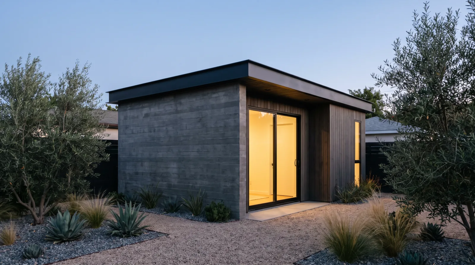 Newly built modern ADU accessory dwelling unit exterior with dark siding and black aluminum doors in a Los Angeles backyard